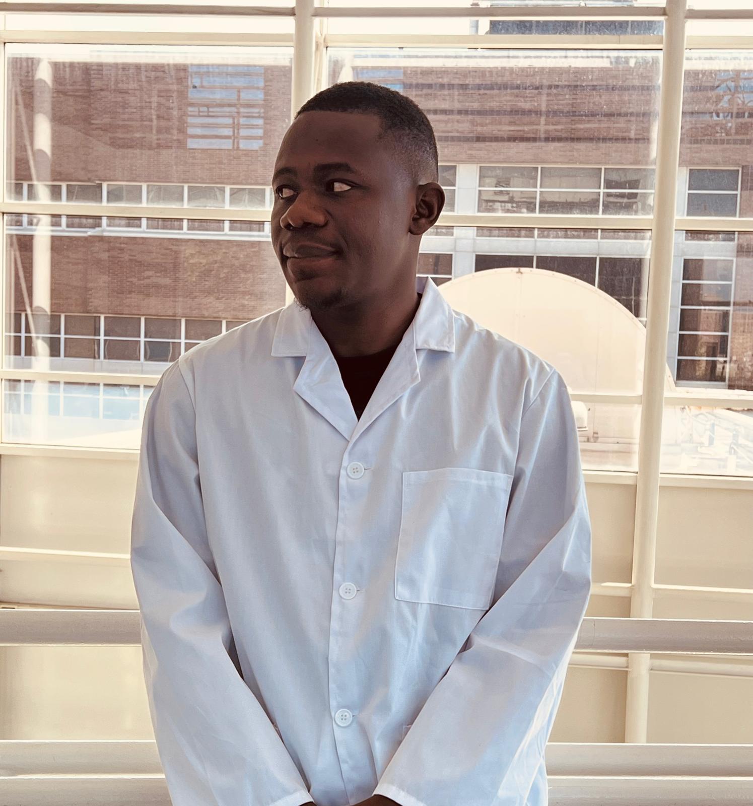 Elvis Ati wearing a white radiography laboratory coat